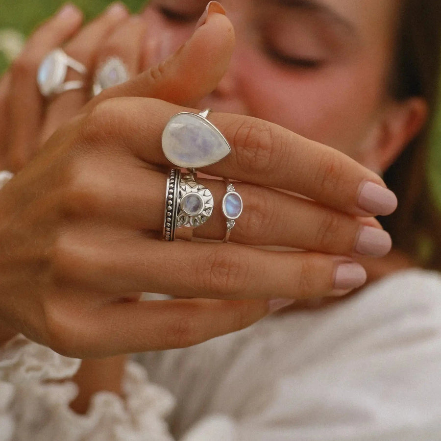 Woman showing her hand to the camera, wearing three moonstone rings