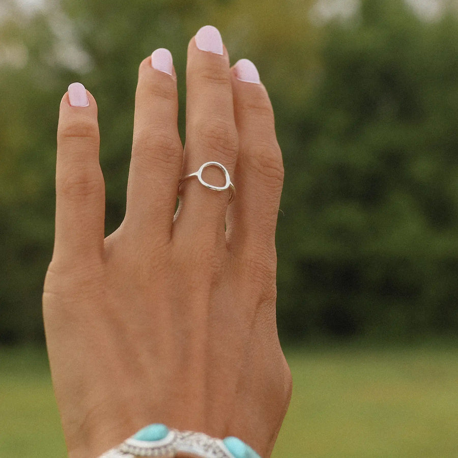 woman wearing one sterling silver ring with a halo shape in the middle