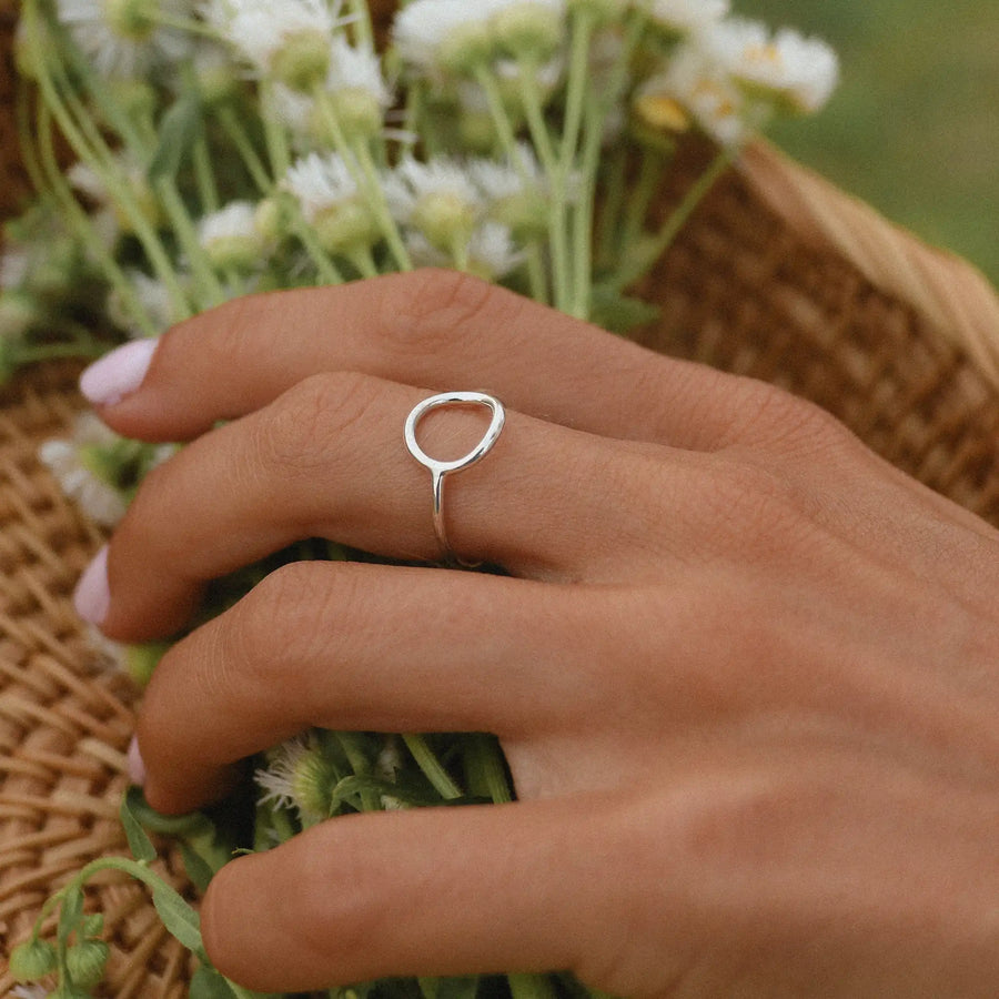woman holding flowers in a basket wearing one sterling silver halo ring