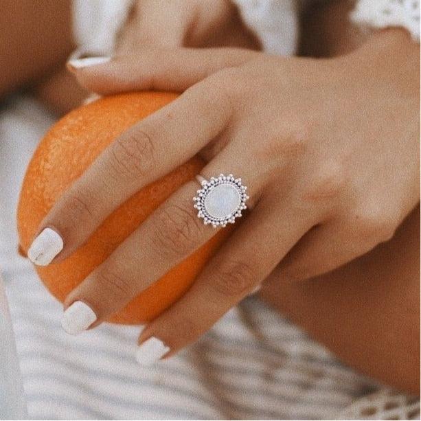 Woman holding an orange and wearing a silver Moonstone Ring - womens moonstone jewellery 