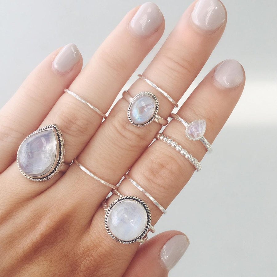 Woman’s hand wearing multiple moonstone rings and sterling silver Stacker Rings - Australian jewellery brand