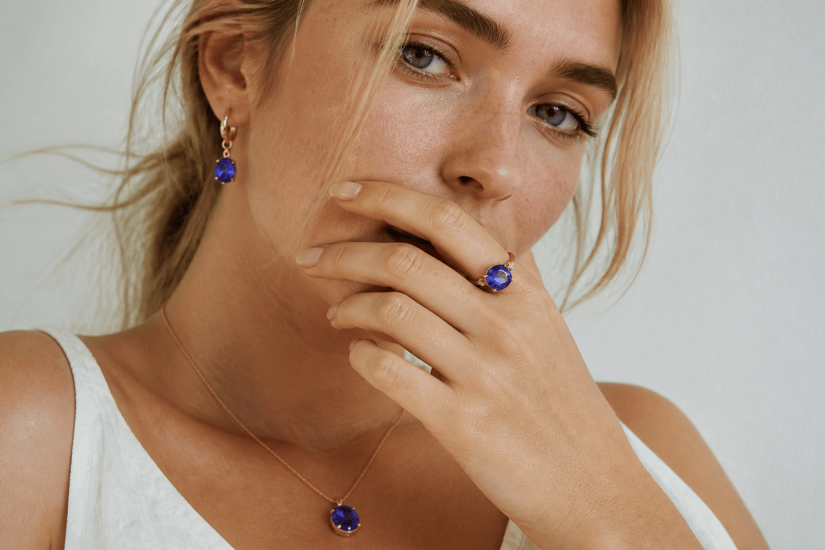 Young woman wearing blue-violet tanzanite jewelry in natural light