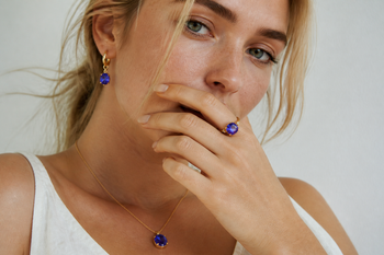 Young woman wearing blue-violet tanzanite jewelry in natural light