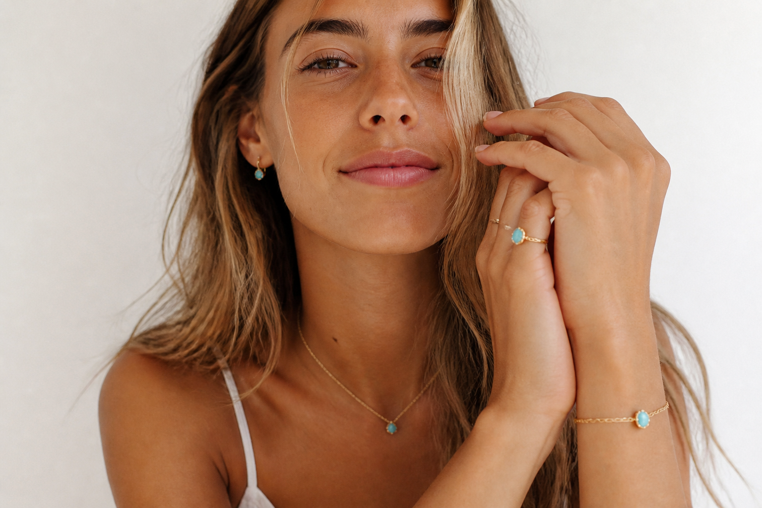 Young woman wearing delicate gold turquoise jewelry in natural light