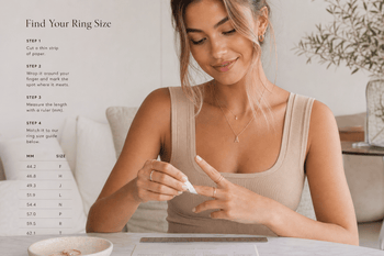 Woman measuring her ring finger at home with a paper strip and ruler