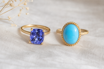 Faceted blue tanzanite jewelry beside blue turquoise jewelry on a neutral background