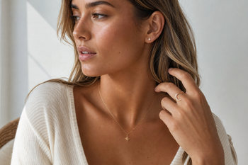 Young woman wearing delicate celestial jewellery including a star necklace, moon ring, and small earrings.