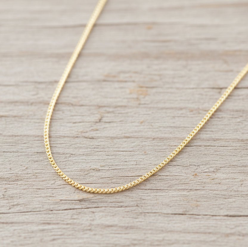 Gold chain necklace on a wooden surface