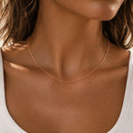 close up of a woman wearing a dainty minimalist 9k rose gold chain necklace with 1mm curb chain design and 16 inch length