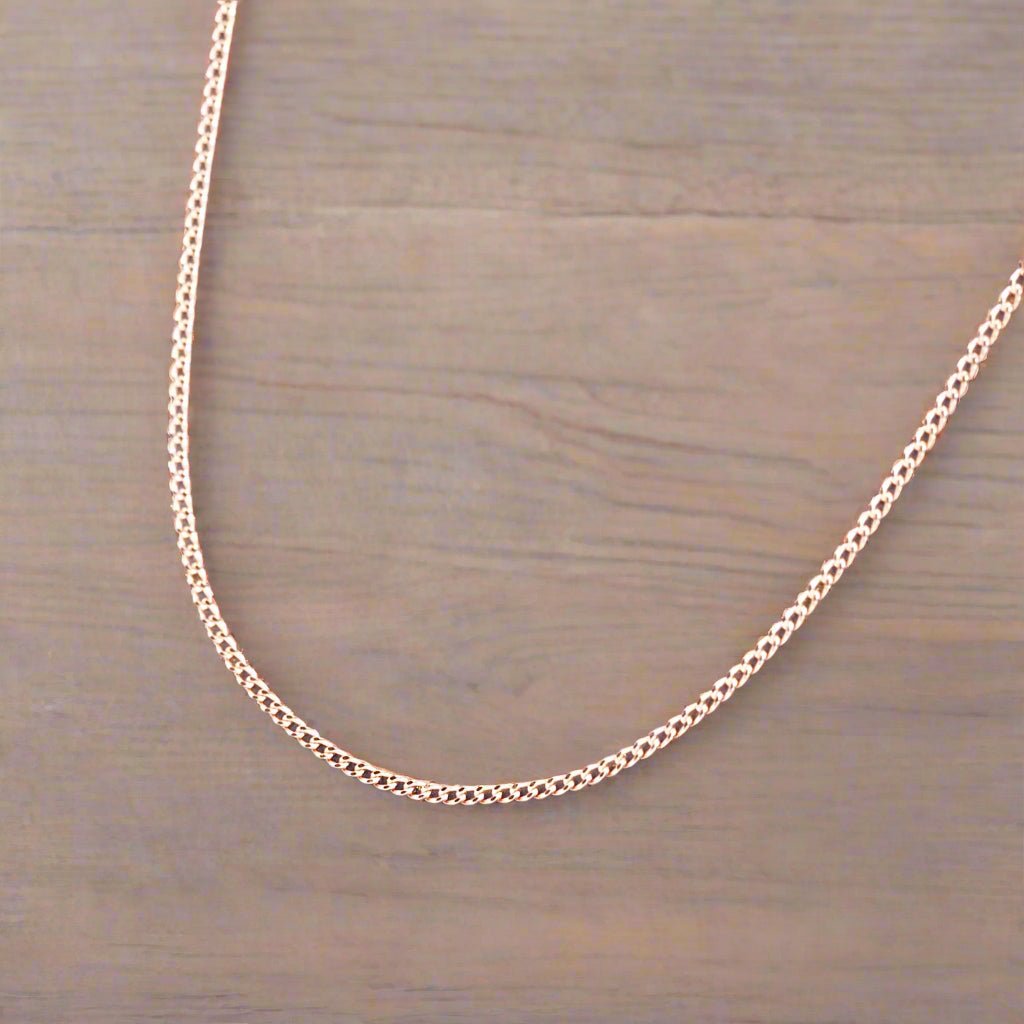 9k Rose Gold plated sterling silver curb chain necklace on a wooden surface