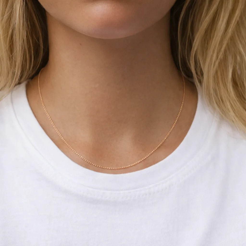 9k rose Gold plated sterling silver curb chain necklace on a person wearing a white shirt