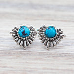 Silver earrings with turquoise stones on a wooden surface