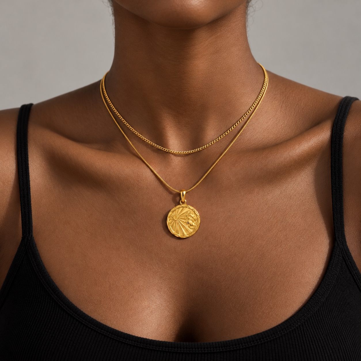 Woman in a black top wearing the gold waterproof zodiac medallion necklace