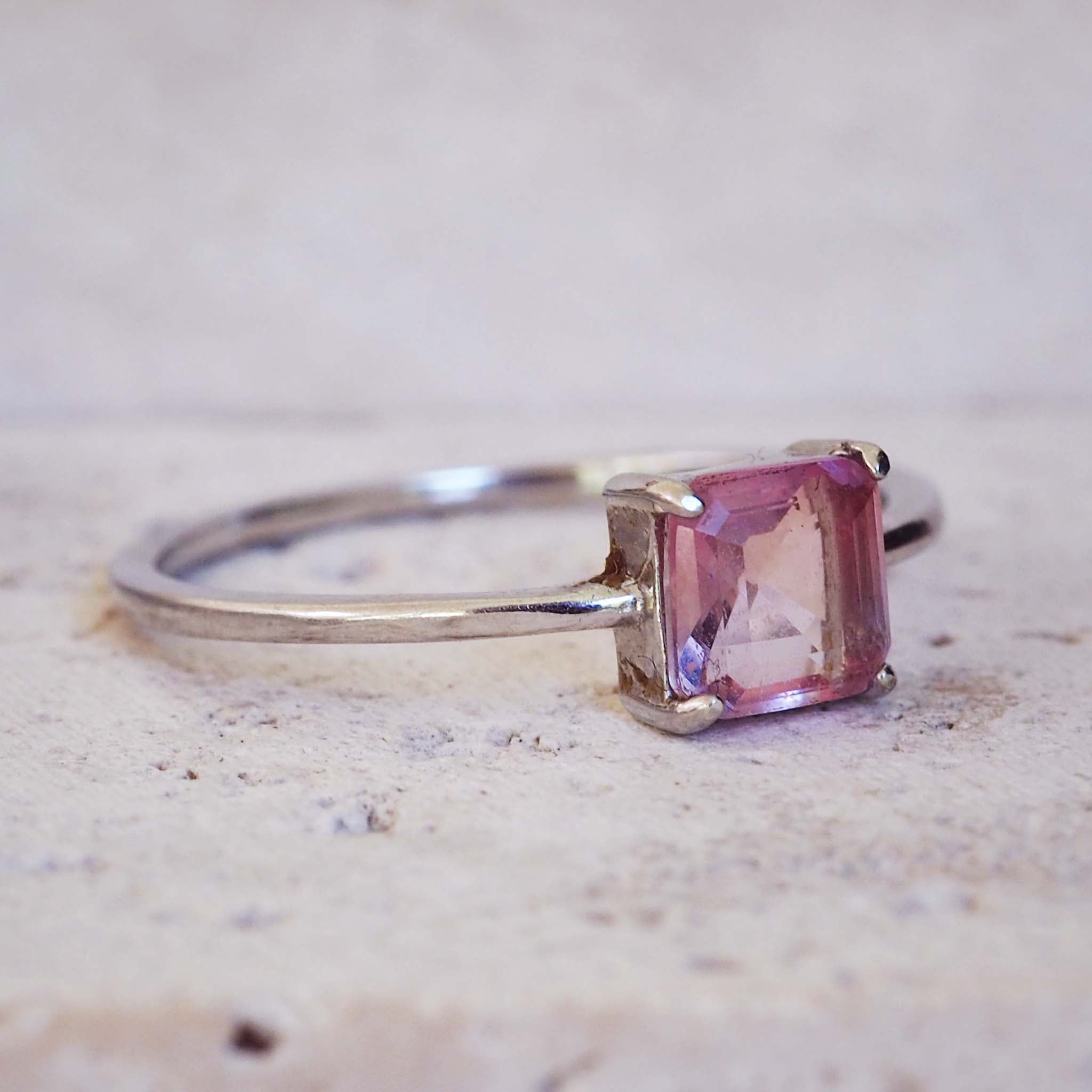 Silver ring with a pink gemstone on a light background