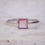 Ring with a pink gemstone on a textured surface