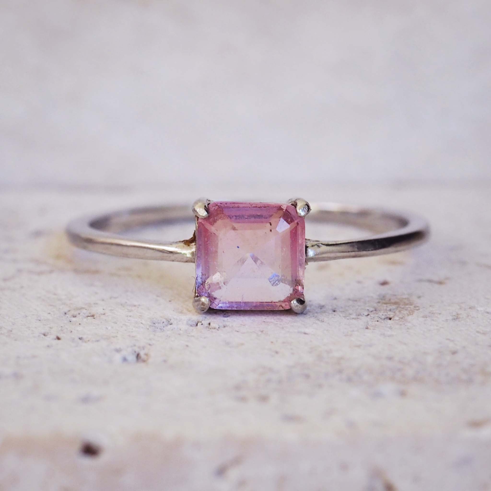 Ring with a pink gemstone on a textured surface