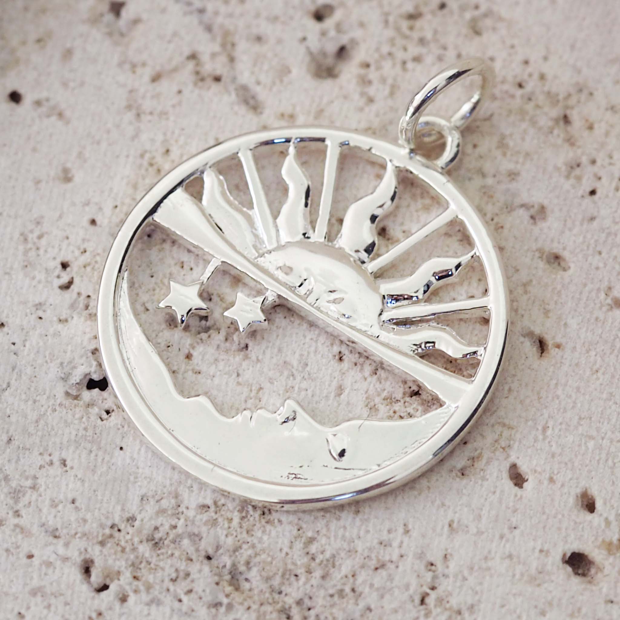 Silver pendant with tree design on a textured beige background