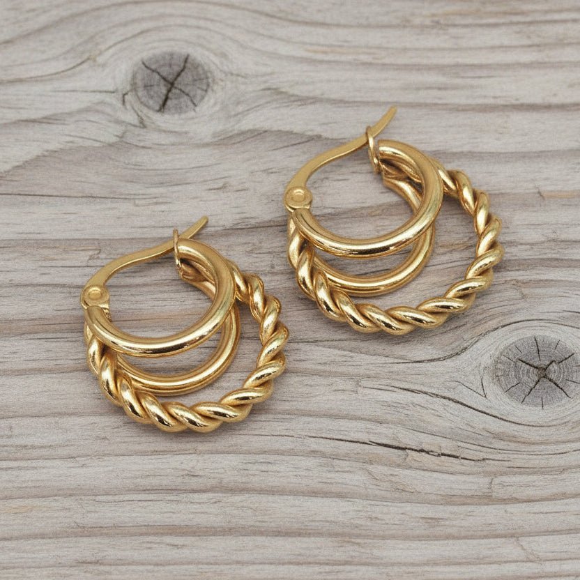 Pair of gold hoop earrings on a wooden surface