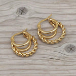 gold hoop earrings on a wooden surface