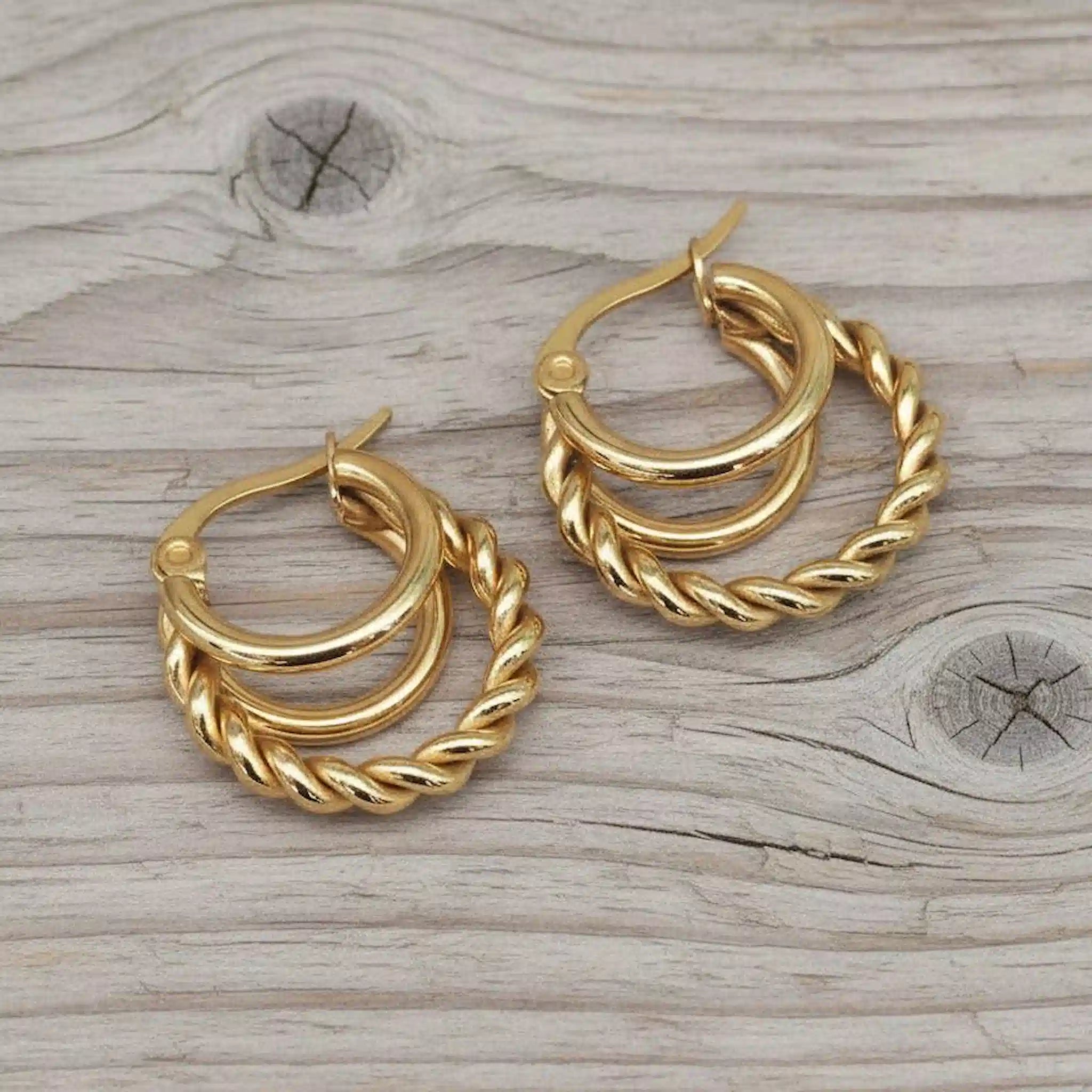 gold hoop earrings on a wooden surface