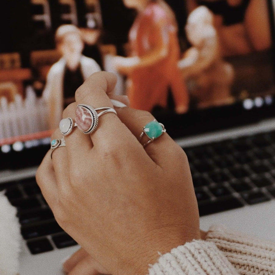 womans hand wearing multiple boho rings