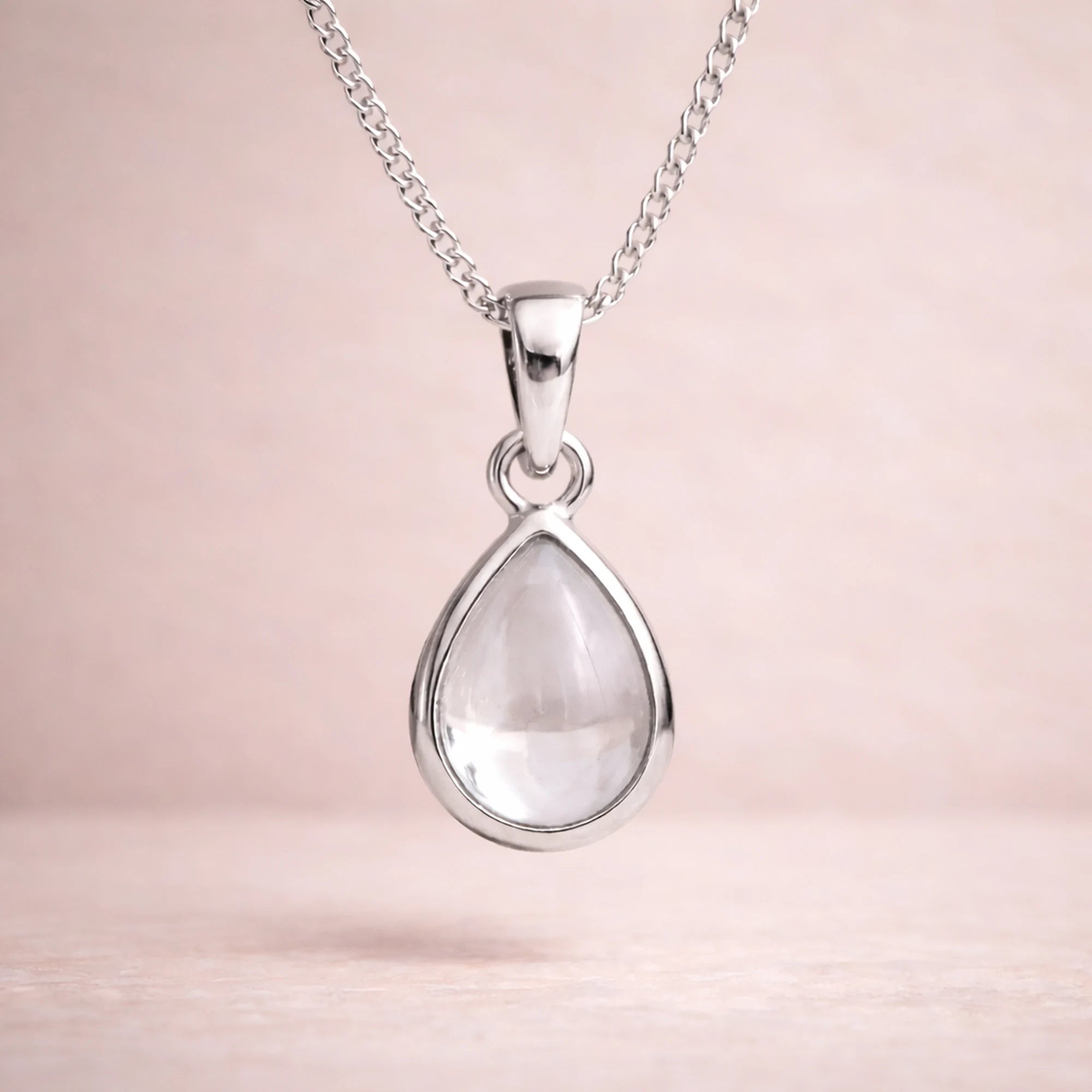 sterling silver necklace with a teardrop-shaped natural herkimer quartz cabochon pendant on a beige background