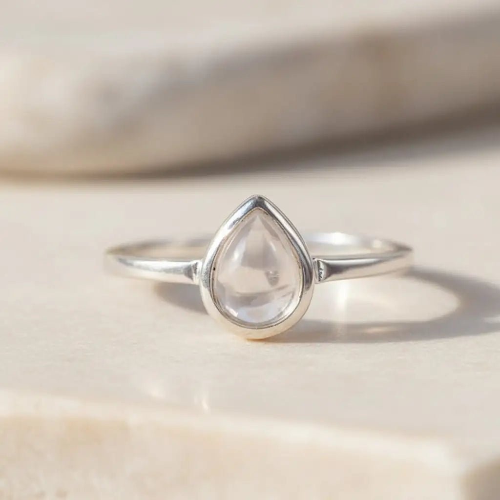 sterling Silver ring with a teardrop-shaped april birthstone clear herkimer quartz gemstone on a light surface
