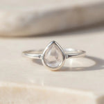 Sterling Silver April birthstone ring with clear herkimer quartz teardrop-shaped stone on a light background