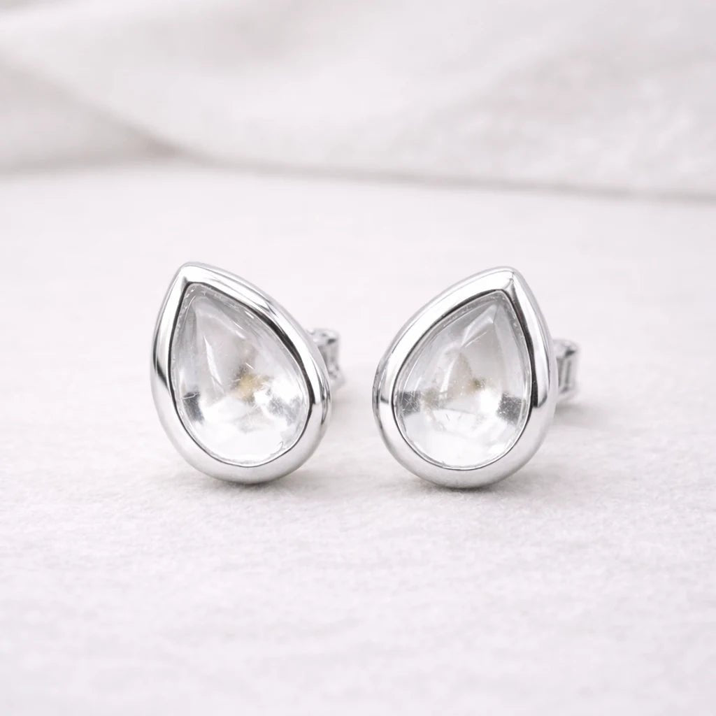 Teardrop-shaped sterling silver stud earrings with clear herkimer quartz gemstones on a white background