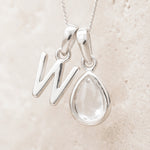 Sterling Silver April Birthstone Necklace with a personalised W initial pendant on a light background