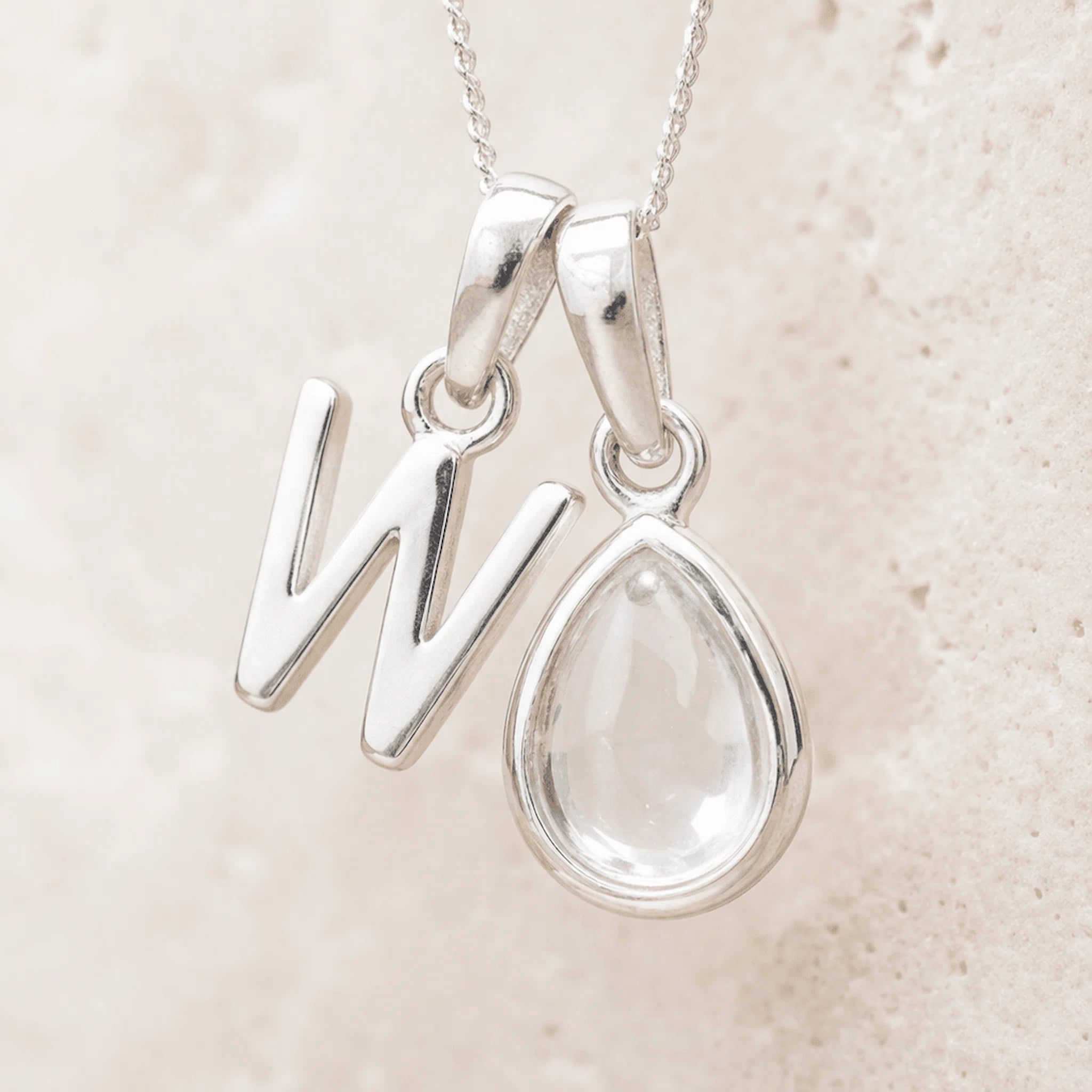 Sterling Silver April Birthstone Necklace with a personalised W initial pendant on a light background