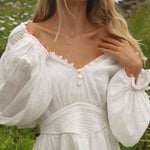 woman in a field wearing a white dress and a dainty constellation necklace