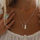 sterling silver S initial pendant and silver zodiac necklace being worn