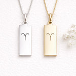silver and gold necklace with aries zodiac symbol