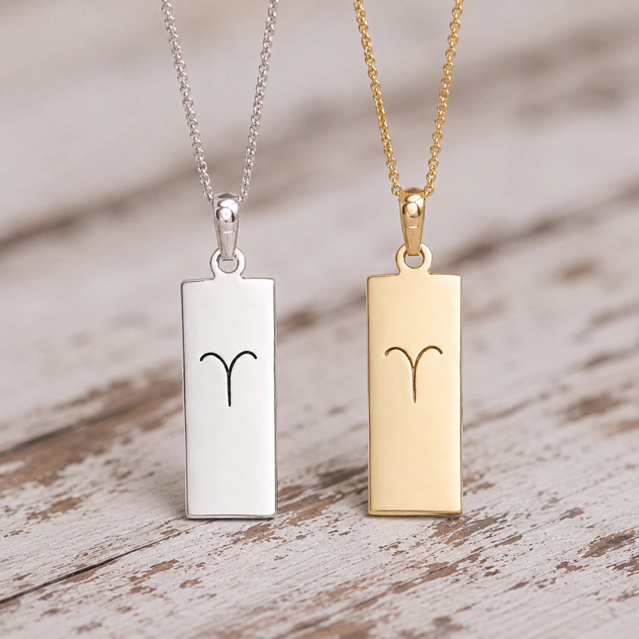 gold and silver fine chain necklaces with rectangle pendants engraved with aries line glyph
