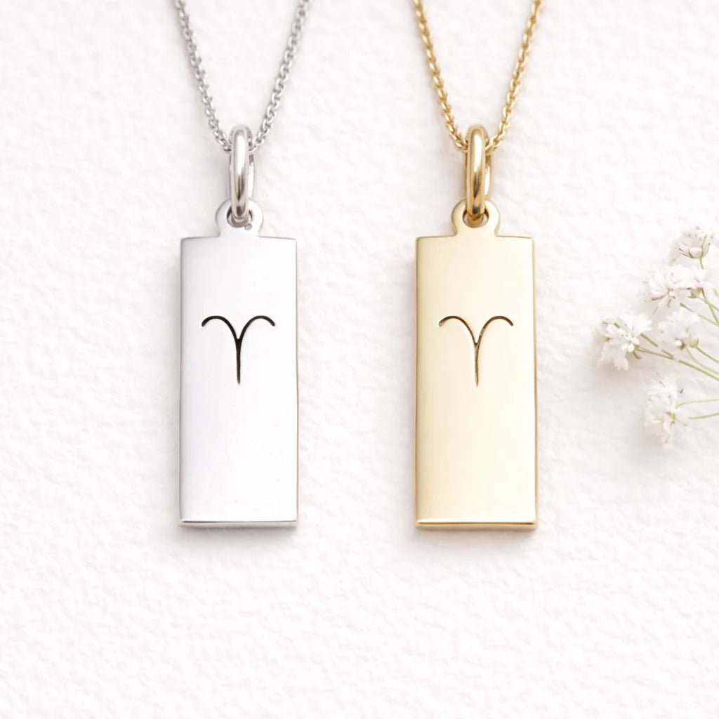 silver and gold necklace with aries zodiac symbol