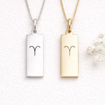silver and gold necklace with aries zodiac symbol