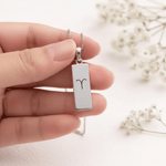 Sterling Silver Aries Zodiac Necklace with minimalist pendant design being held