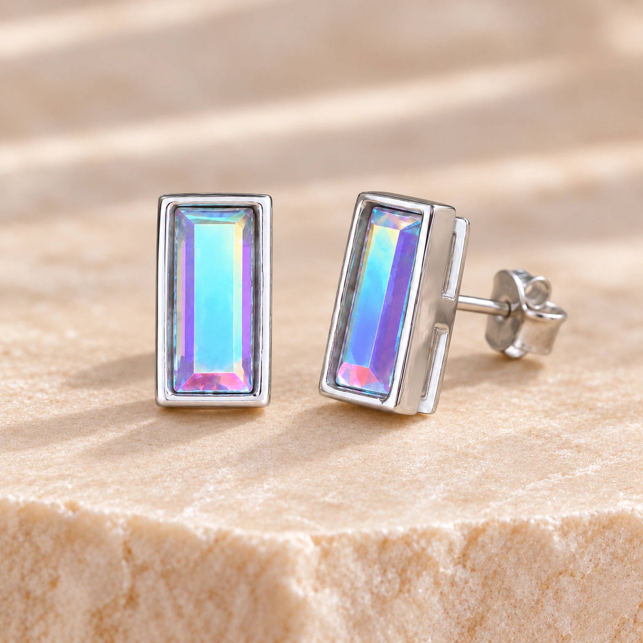 Aurore Boreale crystal baguette stud earrings showing aqua and blue flashes, with a straight post and butterfly backing