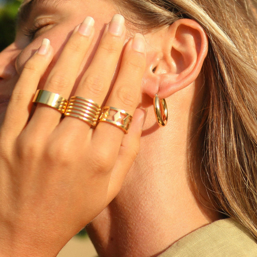 Woman wearing gold earrings and gold rings -  gold waterproof jewellery Australian jewellery brand 