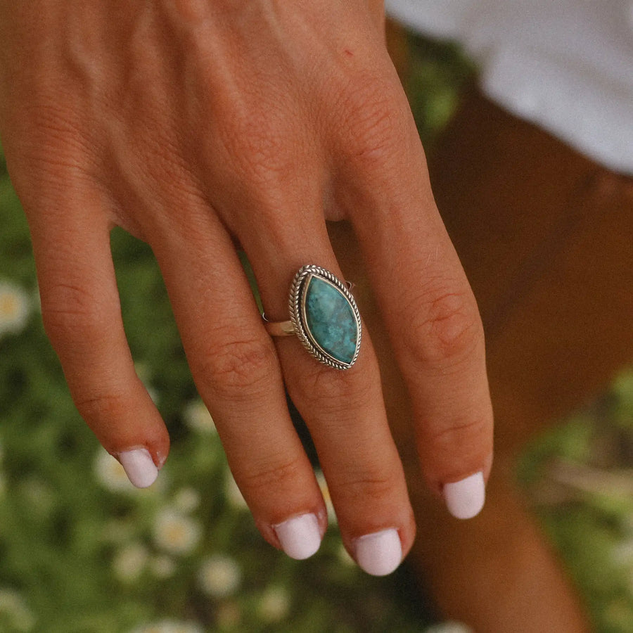 woman's hand with white nail polish, wearing a large sterling silver ring with an azurite stone in it