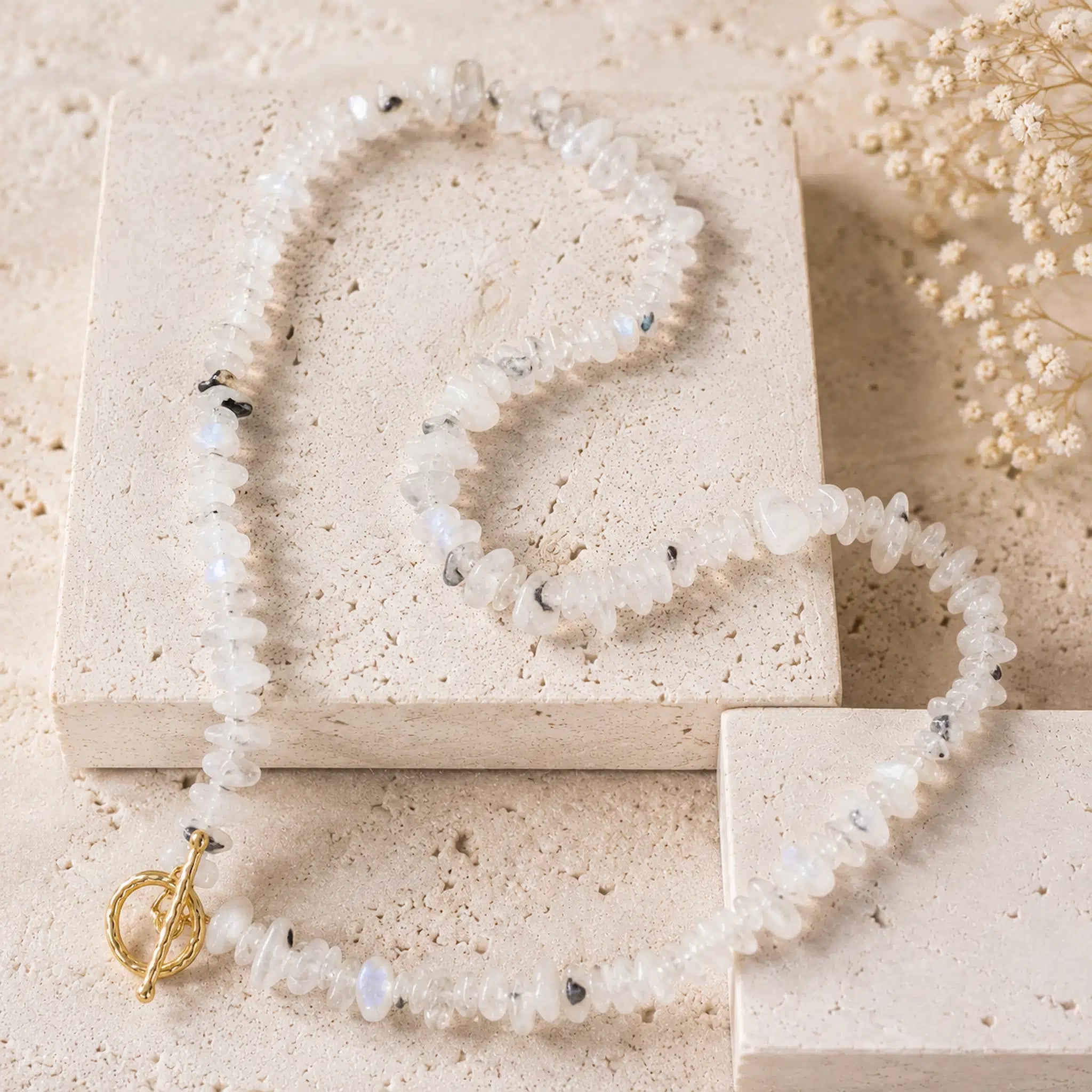 beaded moonstone necklace made of irregular natural moonstone stone chips with small dark inclusions and a gold toggle clasp