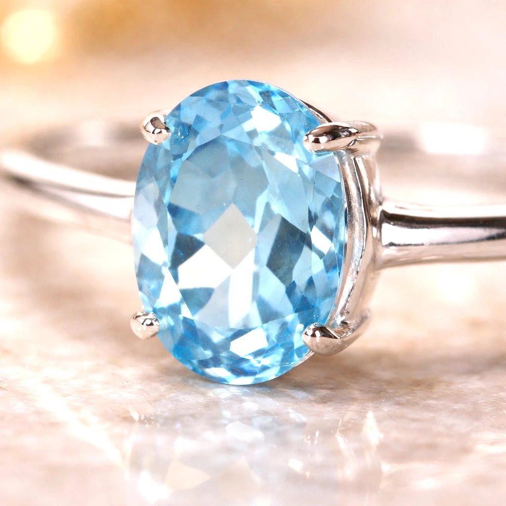 Silver ring with a blue topaz gemstone on a soft focus background