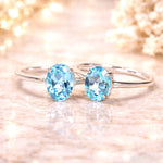 sterling Silver rings with two blue topaz  gemstones on a soft, blurred background