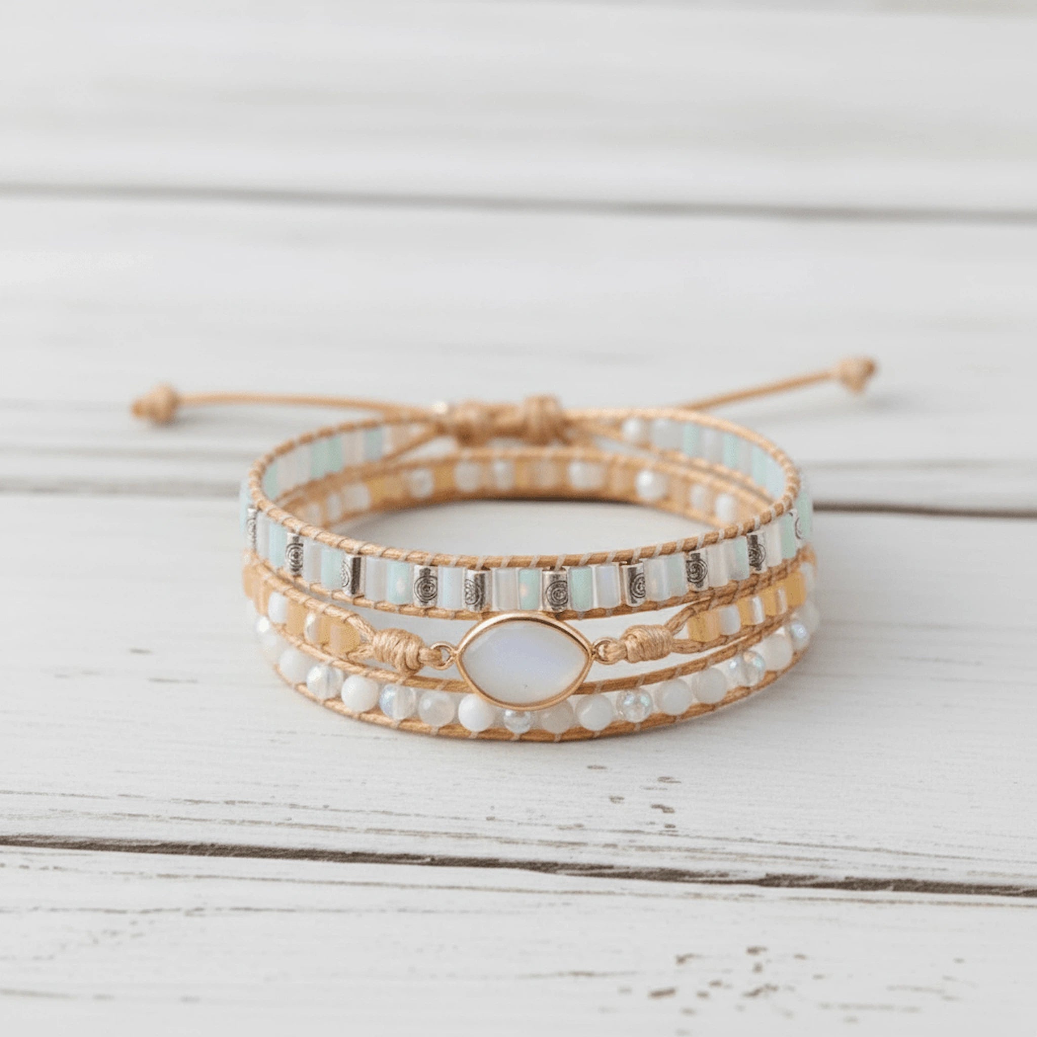 multi wrap boho style natural moonstone gemstone beaded bracelet on a white wooden surface