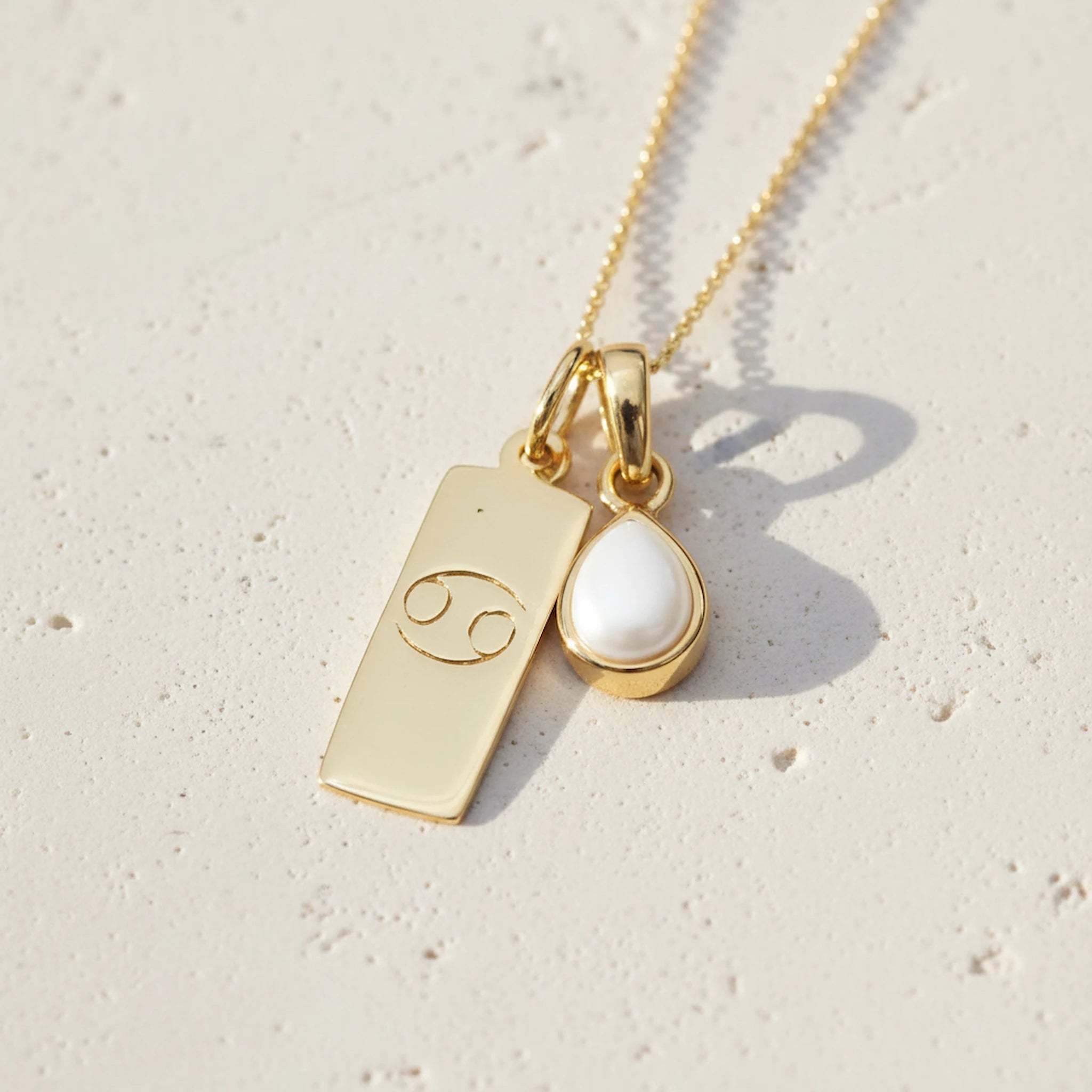 Gold Necklace with a June Birthstone Pearl pendant and a cancer zodiac star sign pendant