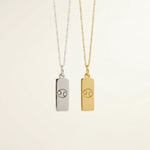 Gold and silver necklaces with cancer zodiac pendants on a beige background