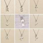 Silver letter pendants from R to Y on a beige background as personalised letter options for the Cancer Zodiac Necklace