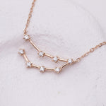 Rose gold constellation necklace on a light gray background