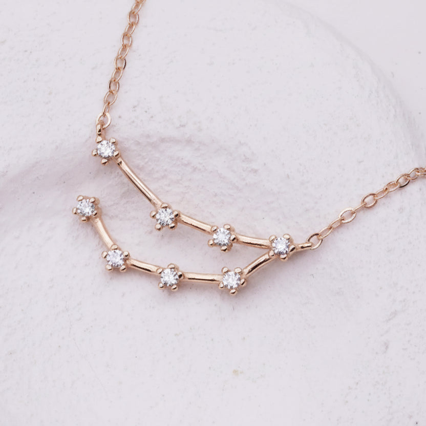 Rose gold constellation necklace on a light gray background